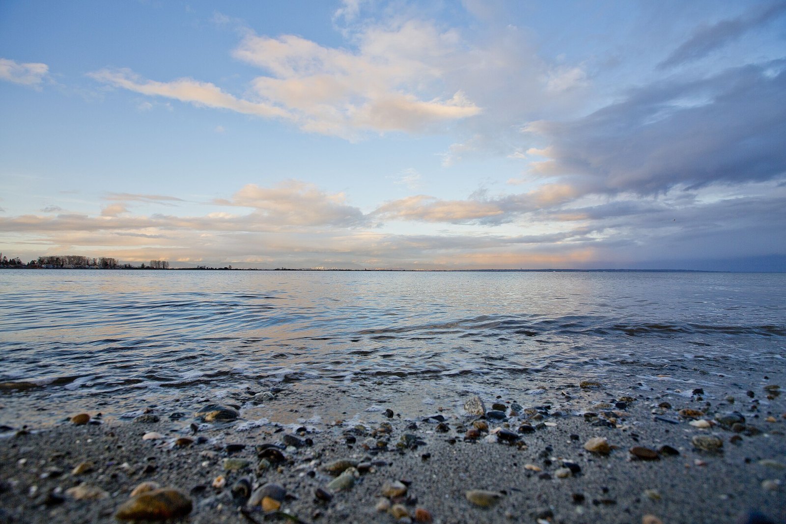 Pebbly Boundary Bay shoreline with distant Vancouver skyline