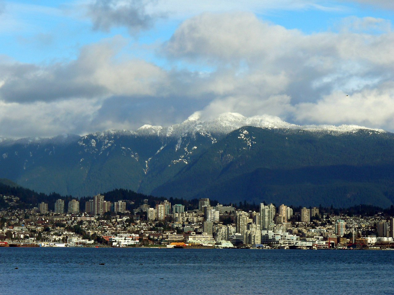 North Vancouver waterfront below snowy North Shore mountains