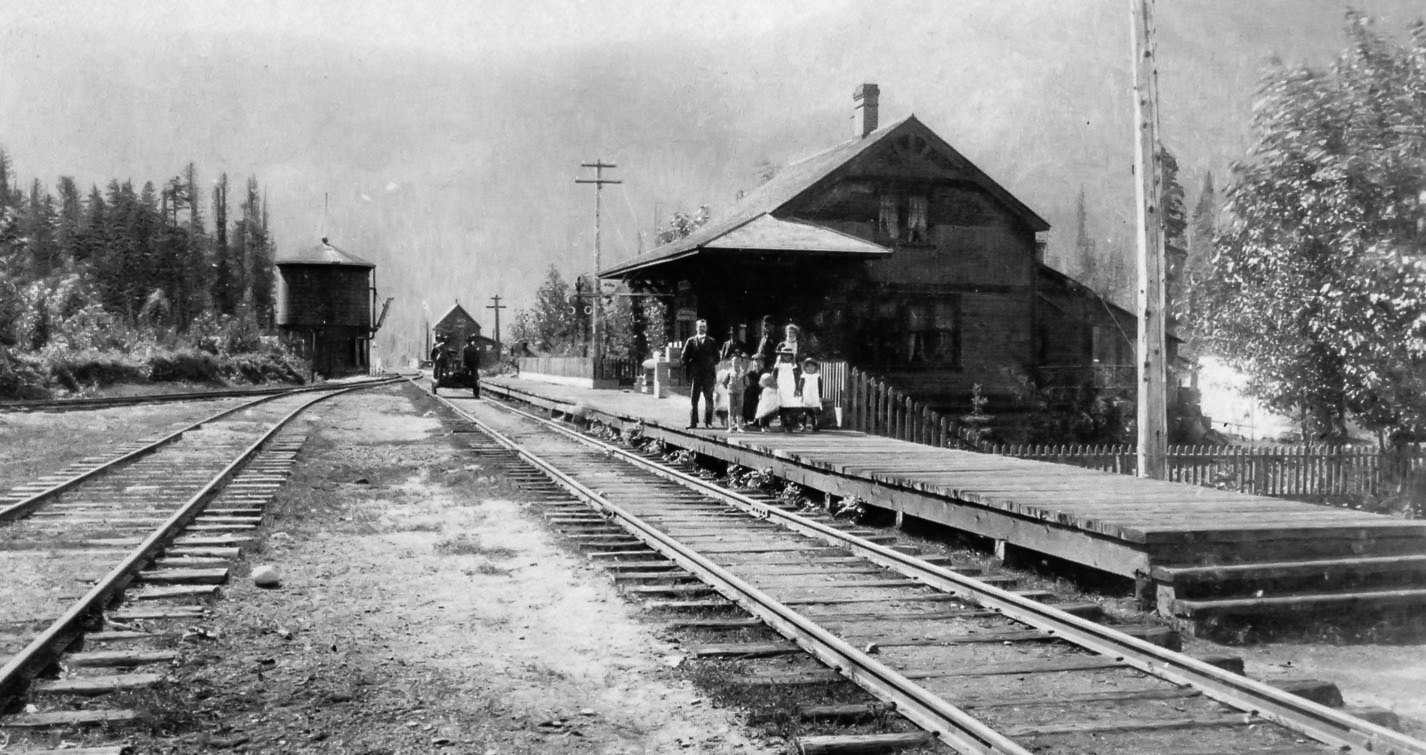 Historic railway station with water tower in forested mountain valley