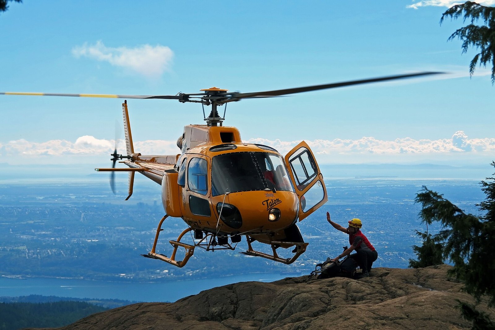 Rescue helicopter landing on North Shore rock bluff above Vancouver