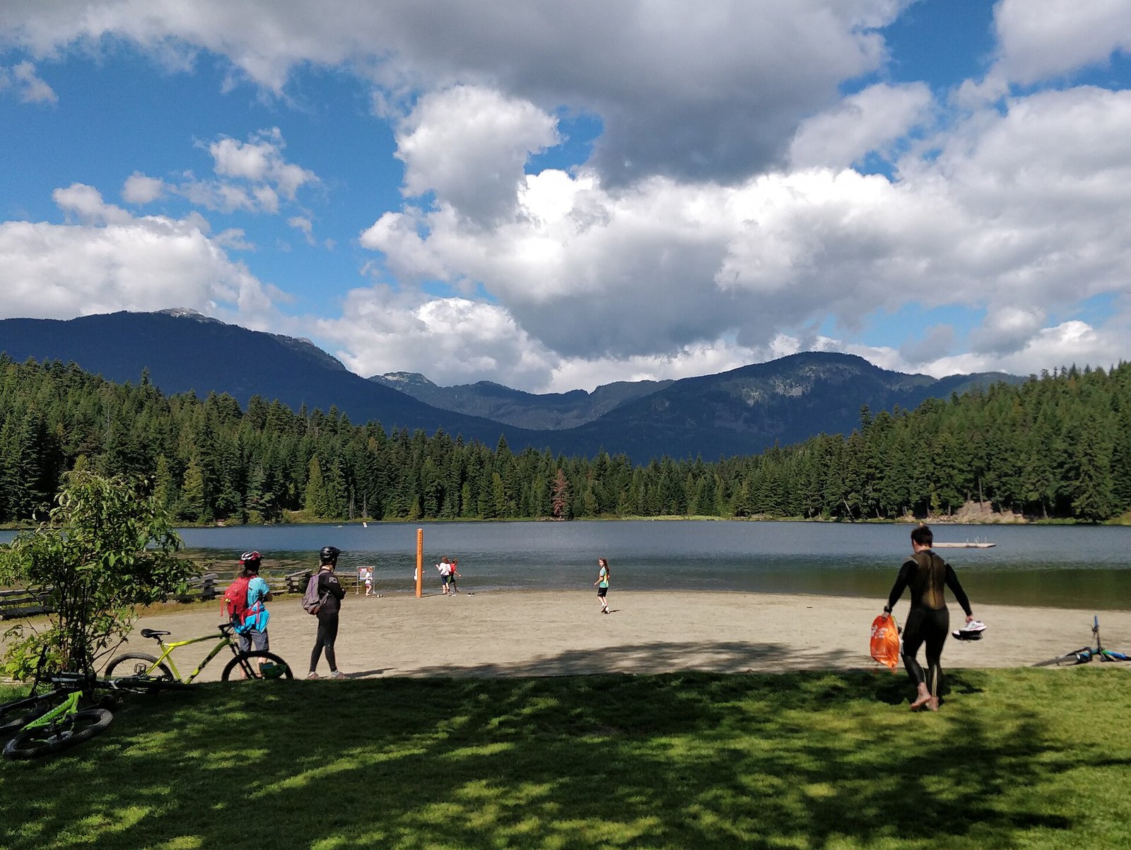 Summer beach at Lost Lake below forested mountains