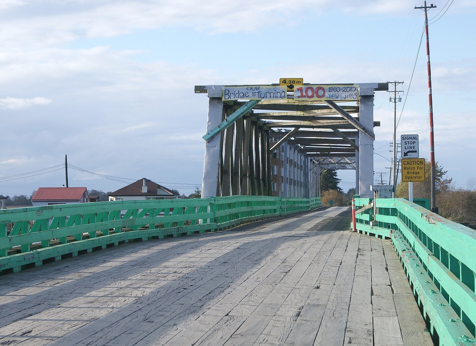 Wooden Westham Island swing bridge with 2010 centennial banner