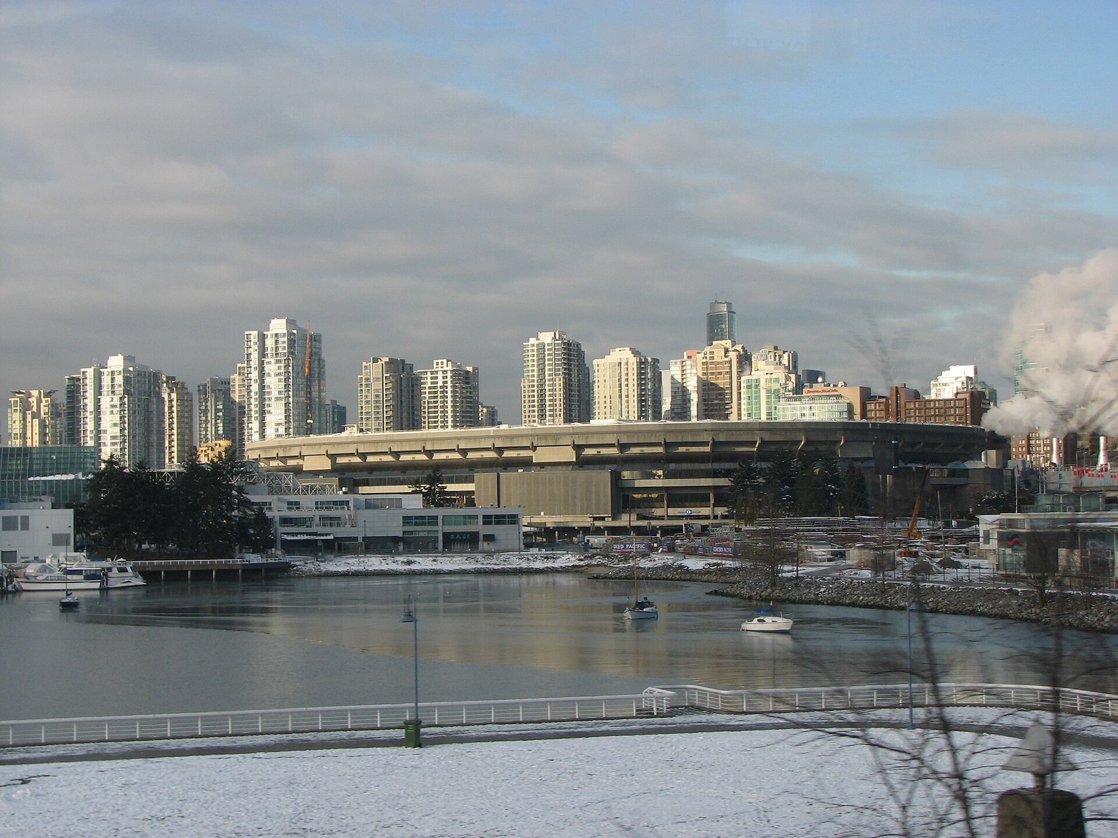 BC Place's deflated fabric roof in the snow, seen across False Creek